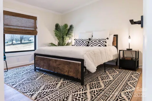 a bedroom with a bed lamp and a rug