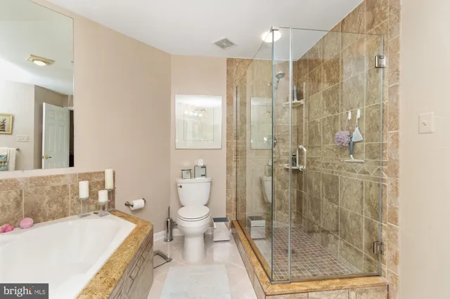 a bathroom with a bathtub shower sink mirror and toilet