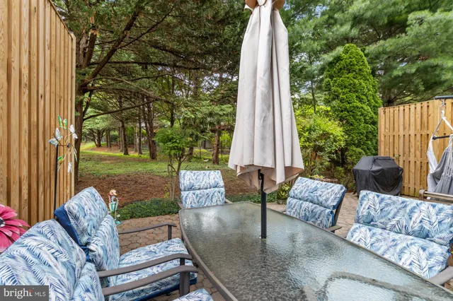 a view of a patio with couches chairs and a floor to ceiling window