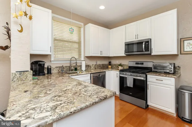 a kitchen with granite countertop a stove sink and microwave