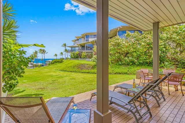 a view of a patio with lawn chairs floor to ceiling window and yard