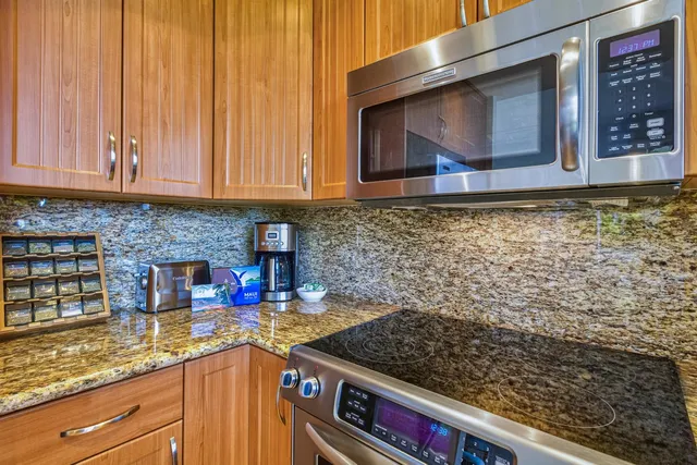 a kitchen with stainless steel appliances granite countertop a stove and a microwave