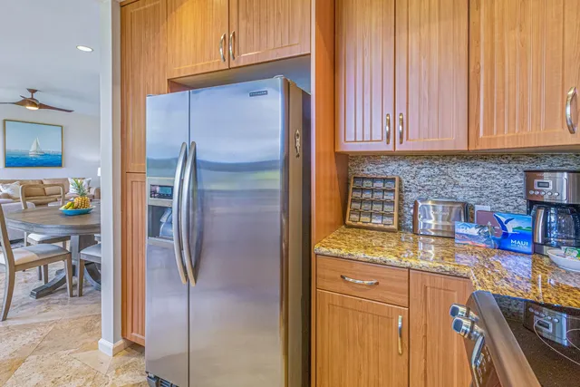 a kitchen with stainless steel appliances granite countertop a refrigerator and a stove