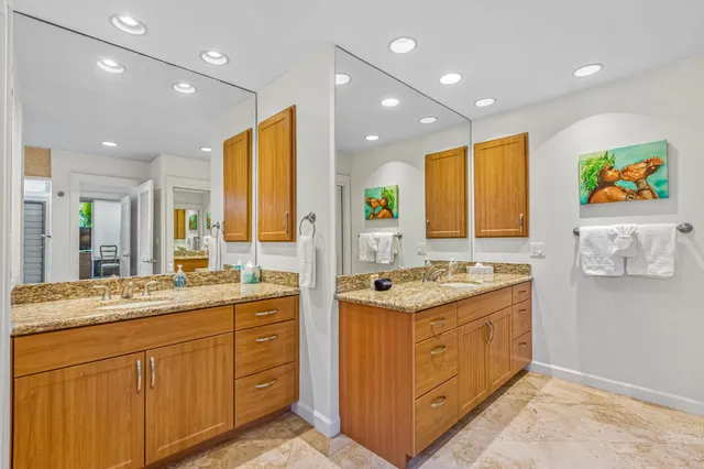 a bathroom with a granite countertop sink a mirror and shower