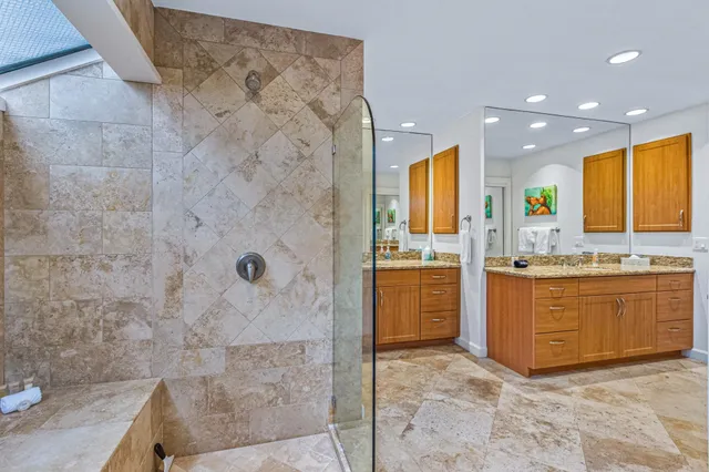 a bathroom with a granite countertop sink mirror and shower