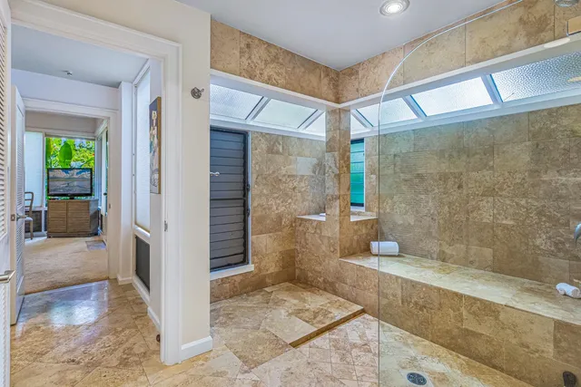 a bathroom with a granite countertop sink a mirror and a shower