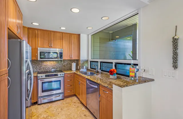 a kitchen with stainless steel appliances granite countertop a stove sink and refrigerator