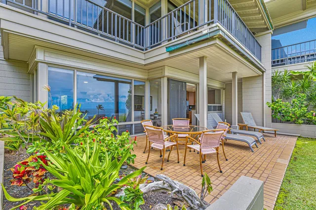 front view of a house with a chairs and table in a patio