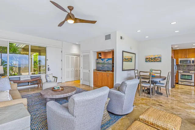 a living room with furniture kitchen view and a large window