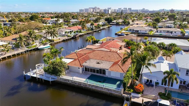 an aerial view of residential houses with outdoor space and trees