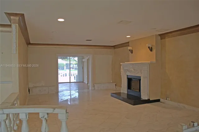 a view of empty room with fireplace and windows