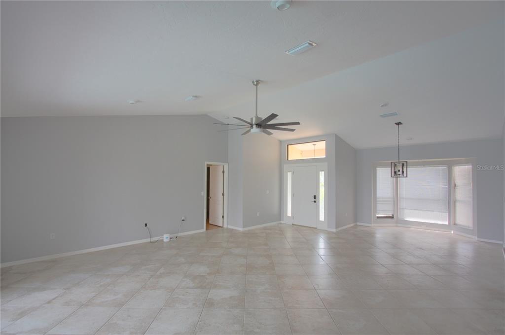 6907 Ranch Road Sarasota, FL 34243 - Photo 2 of 14 an empty room with chandelier fan and windows