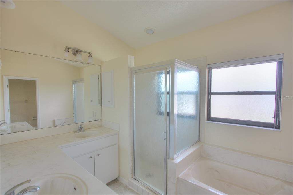 6907 Ranch Road Sarasota, FL 34243 - Photo 5 of 14 a bathroom with a granite countertop sink mirror and a bathtub