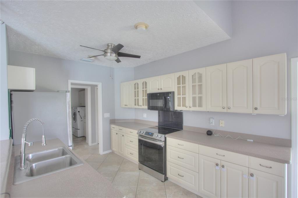 6907 Ranch Road Sarasota, FL 34243 - Photo 7 of 14 a kitchen with cabinets stainless steel appliances and a counter space