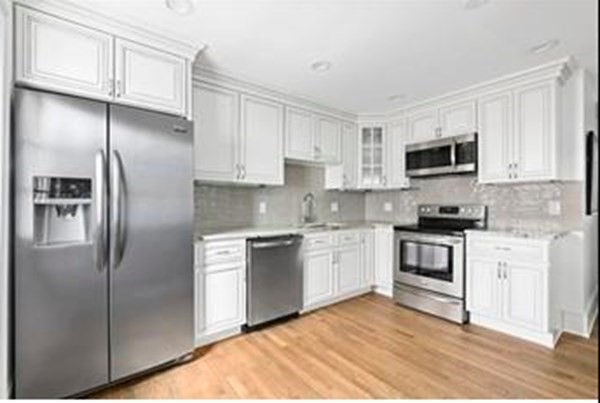 a kitchen with cabinets stainless steel appliances and a window
