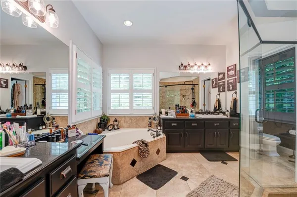 a bedroom with a bed dresser and a large mirror next to a window