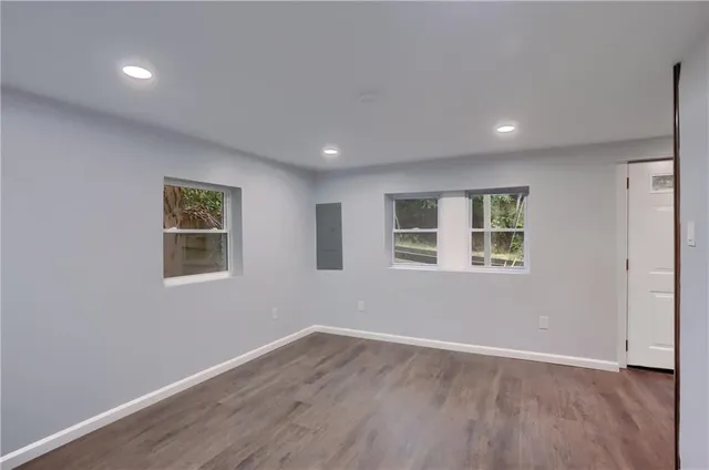 a view of a big room with wooden floor and windows