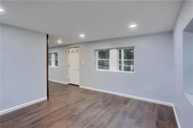 an empty room with wooden floor and a window