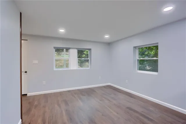 a kitchen with stainless steel appliances granite countertop a sink dishwasher a stove and white countertops with wooden floor