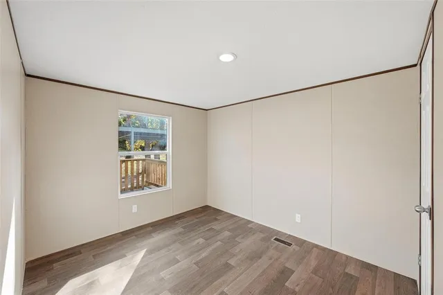 a view of an empty room with a window and closet area