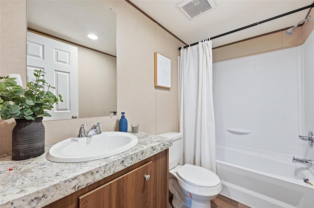 279 Carlisle Court Springtown, TX 76082 - Photo 14 of 18 a bathroom with a granite countertop sink toilet and shower