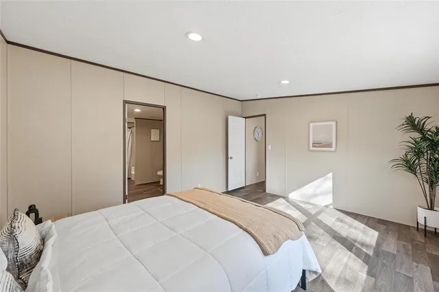 a bedroom with a large bed and a potted plant