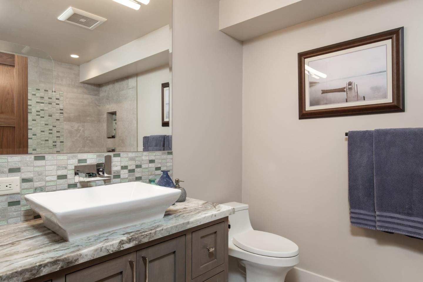 3292 Martin Road Carmel, CA 93923 - Photo 18 of 27 a bathroom with a granite countertop toilet a sink and mirror