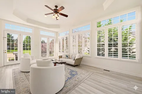 a kitchen with stainless steel appliances granite countertop sink stove and white cabinets with wooden floor
