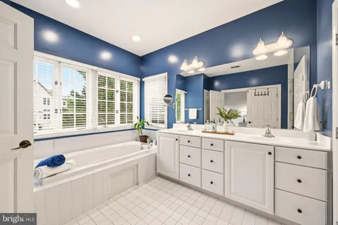 a bathroom with a sink a toilet and a large mirror
