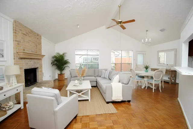 a living room with furniture a fireplace and a large window