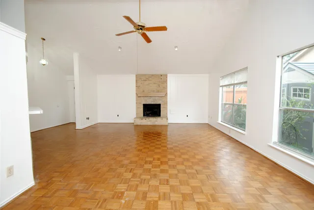 a view of empty room with fireplace and windows