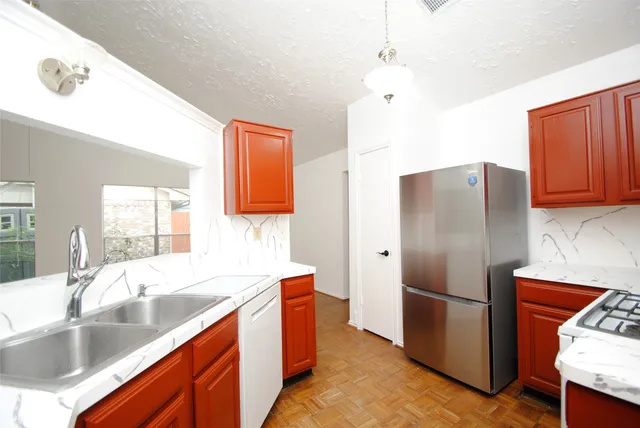 a kitchen with stainless steel appliances granite countertop a refrigerator a sink dishwasher a stove with wooden cabinets