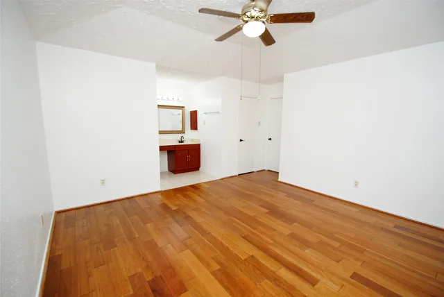 a view of empty room with wooden floor