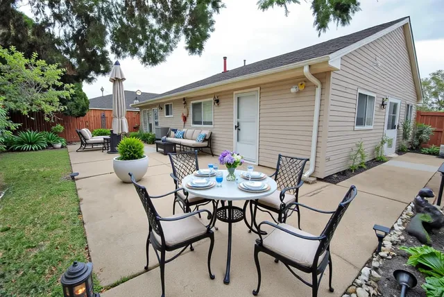 a backyard of a house with table and chairs