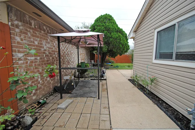 a view of a patio with table and chairs under an umbrella