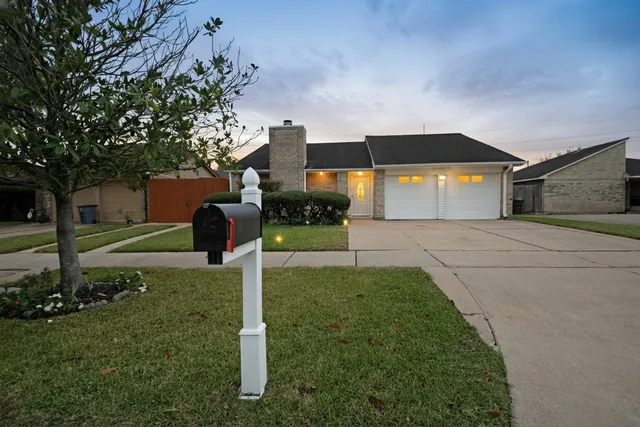 a front view of a house with a yard and trees