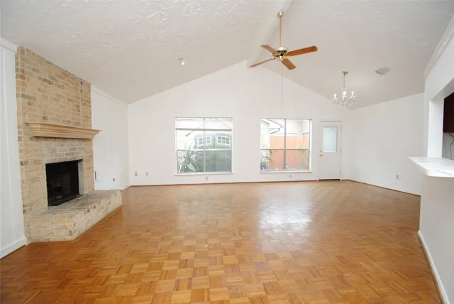 a view of an empty room with a fireplace and a window