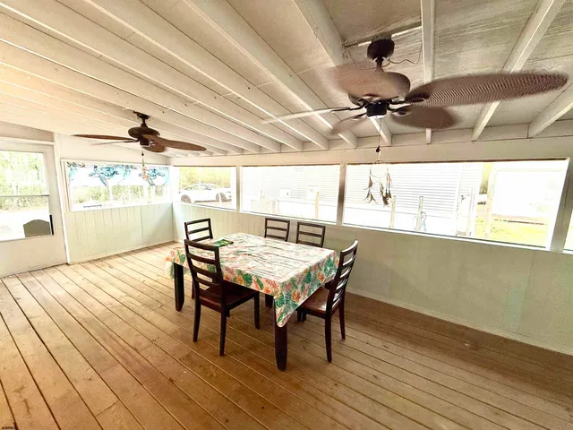 a dining room with wooden floor a chandelier a wooden table and chairs