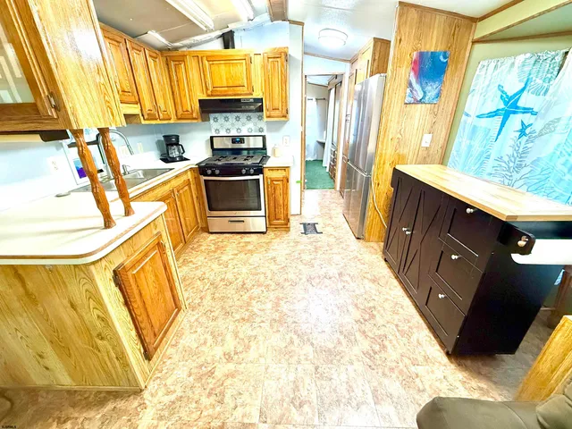 a kitchen with stainless steel appliances a stove a sink and a refrigerator
