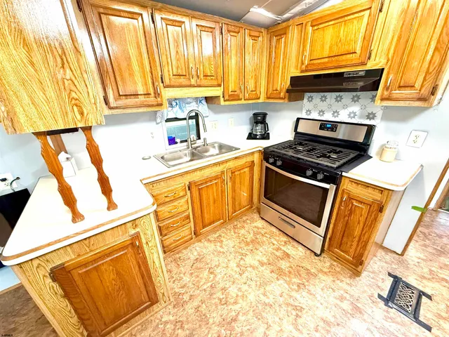 a kitchen with a stove a sink and a refrigerator