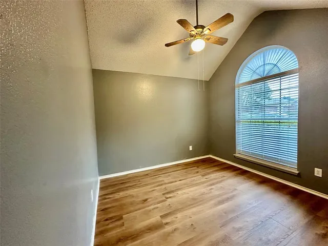 an empty room with windows and fan