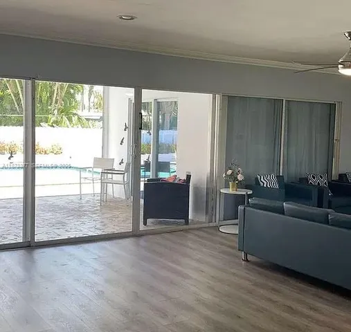 a living room with furniture and a floor to ceiling window