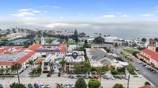 an aerial view of a multi story parking building with yard and mountain view in back