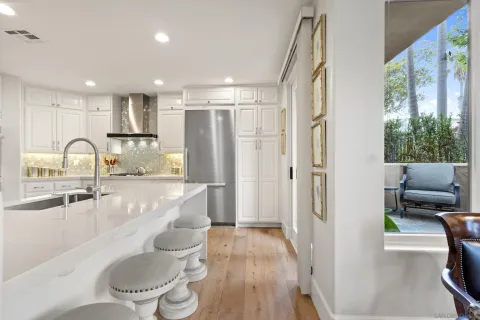 a kitchen with kitchen island white cabinets and refrigerator