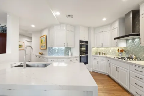 a kitchen with white cabinets and refrigerator