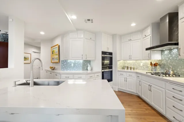 a kitchen with white cabinets and refrigerator