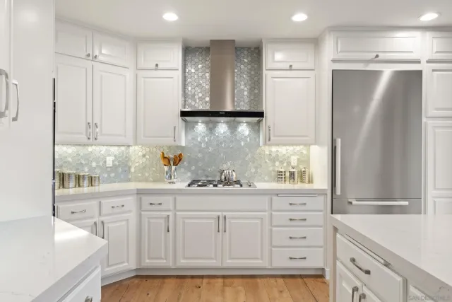 a kitchen with white cabinets and appliances