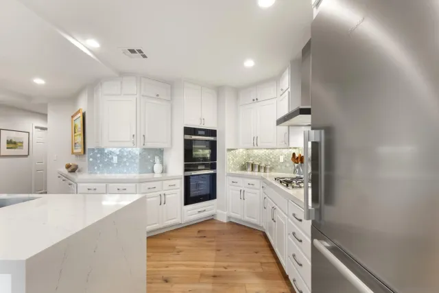 a kitchen with white cabinets and appliances
