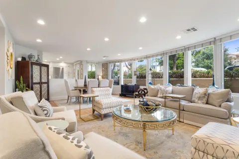 a living room with furniture and a dining table with garden view