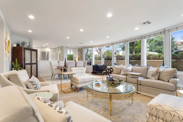 a living room with furniture and a dining table with garden view